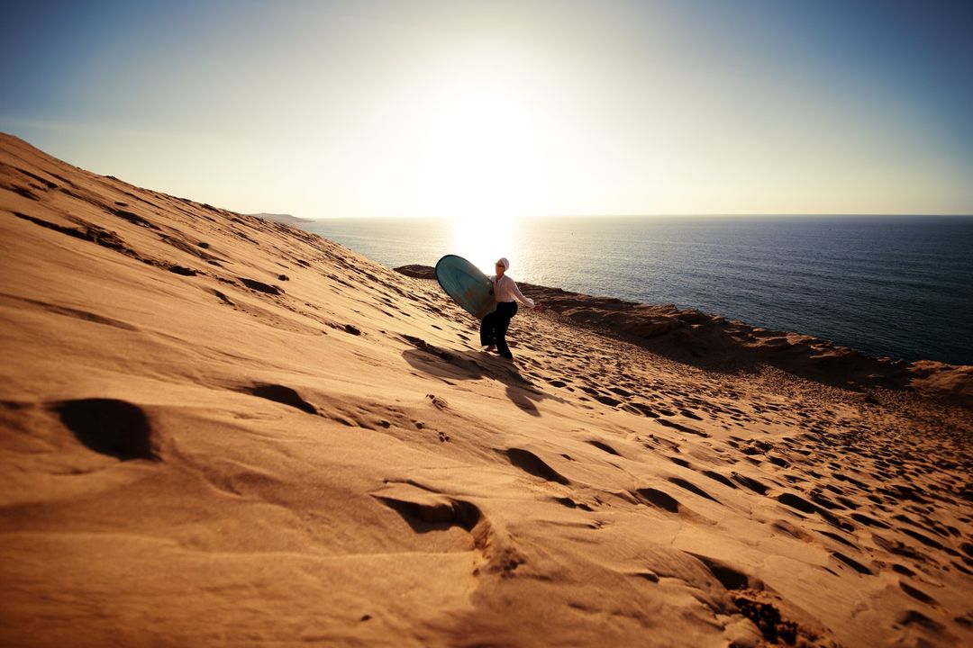 Sandboarding in the desert with panoramic sunset view - Sandboard & Sunset Quest